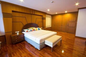 Spacious bedroom with wooden floor and ample wardrobes