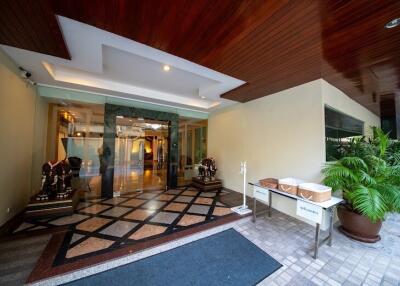 Spacious and elegantly designed lobby entryway with wooden ceiling and tiled flooring