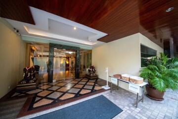 Spacious and elegantly designed lobby entryway with wooden ceiling and tiled flooring