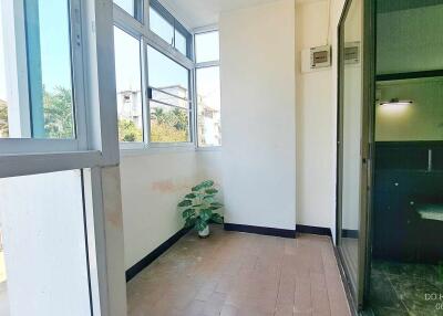 Bright enclosed sunroom with large windows and tile flooring