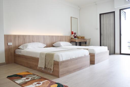 Bright and spacious bedroom with twin beds and wooden furnishings