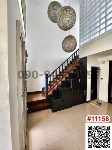 Spacious entrance hallway with elegant staircase and unique pendant lights