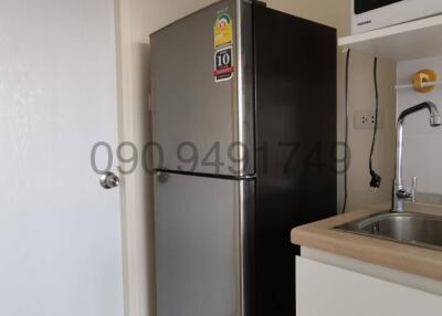 Compact kitchen with stainless steel refrigerator and sink