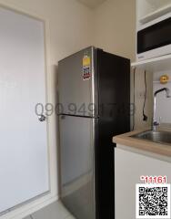 Compact kitchen with stainless steel refrigerator and sink