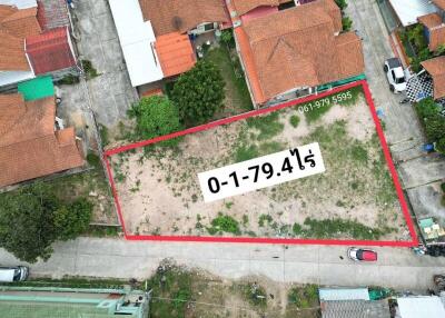 Aerial view of a land plot outlined for property development with contact information