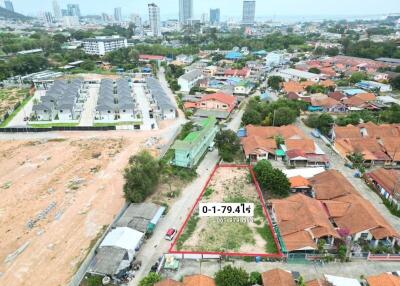Aerial view of a residential area with a vacant plot of land outlined for sale