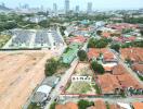 Aerial view of a residential area with a vacant plot of land outlined for sale