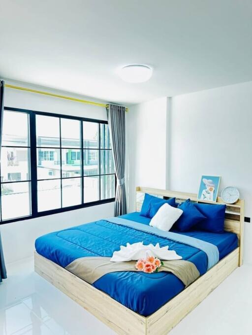 Bright and modern bedroom with large windows and cozy blue bedding