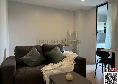 Modernly furnished living room with sofa and open doorway to another room