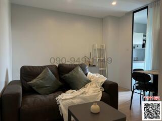 Modernly furnished living room with sofa and open doorway to another room