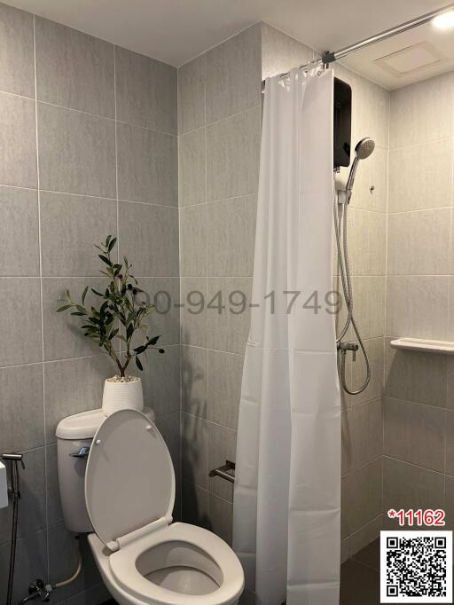 Modern bathroom with grey tiles and a white shower curtain