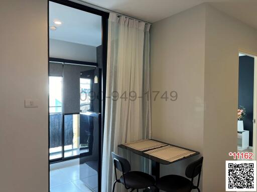 Compact dining area with table for two, adjacent to a balcony with sliding glass doors