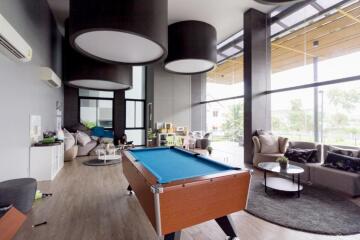 Spacious living room with billiard table, large windows, and modern decor