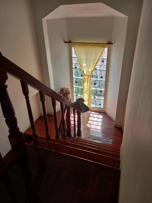 Elegant staircase with wooden banister and window light