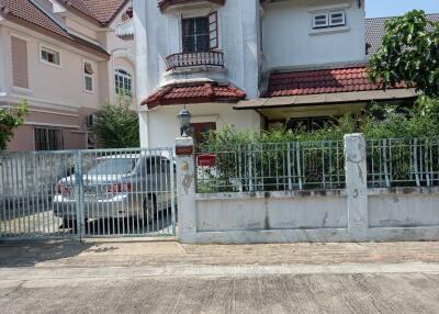 Two-story residential house with a red-tiled roof and a front gate