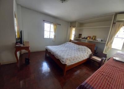 Spacious bedroom with large bed, hardwood floors, and ample natural light