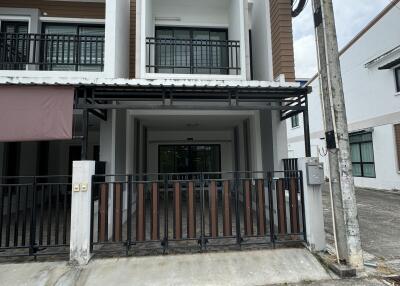 Modern two-story residential townhouse with balcony and metal fence