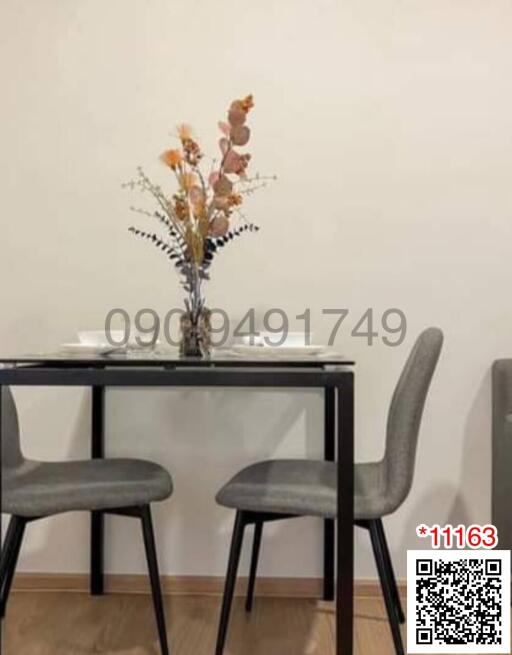 Compact dining table with modern chairs and decorative vase in a clean, minimalistic space