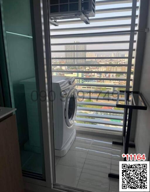 Compact laundry area with washing machine and city view