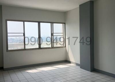 Empty bedroom with tiled floor and large windows