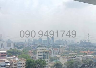 Cityscape view from a high-rise building balcony with contact information overlay