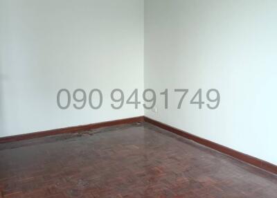 Empty bedroom with hardwood flooring and white walls