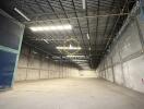 Spacious empty warehouse interior with high ceiling and industrial lighting