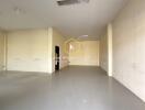 Spacious empty interior space of a building with white walls and tiled flooring