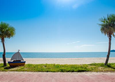 Beachfront view with tent and palm trees