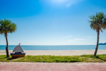 Beachfront view with tent and palm trees