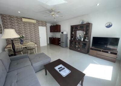 Spacious living room with modern furniture and attached kitchenette