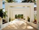 Elegant open-air entrance hallway with sequential archways leading to a tropical garden