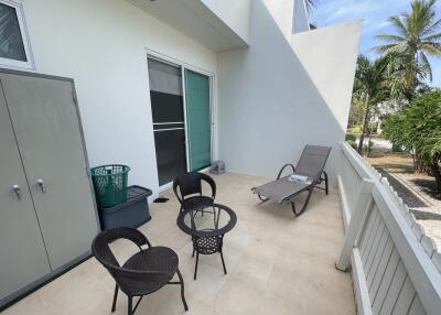 Spacious patio area with seating and surrounding greenery