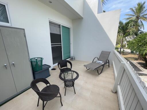 Spacious patio area with seating and surrounding greenery