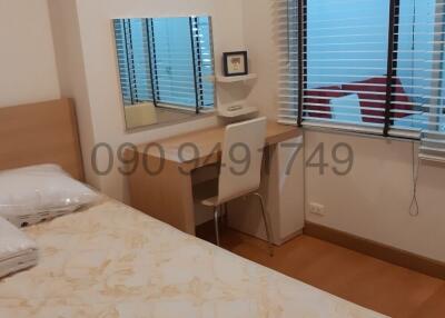 Cozy bedroom with a large window and wooden flooring