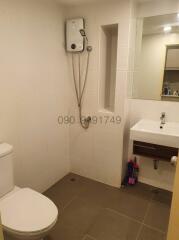 Compact bathroom with white wall tiles, shower, toilet, and sink