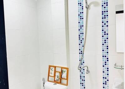 Compact modern bathroom with white tiling and shower