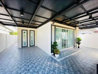 Covered outdoor patio area with tiled flooring and modern sliding doors