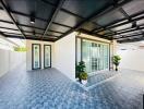 Covered outdoor patio area with tiled flooring and modern sliding doors