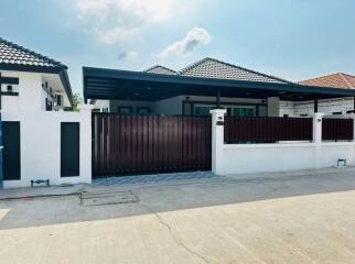 Front view of a modern residential house with a gated entrance