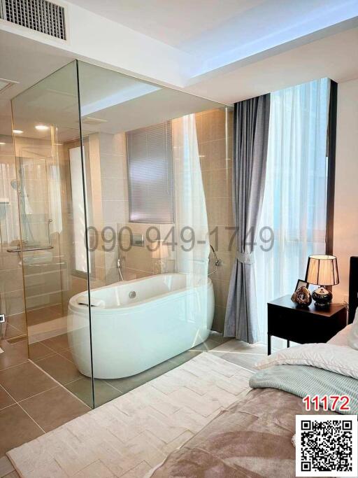 Modern bedroom with an en-suite glass-walled bathroom