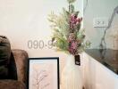 Elegant corner of a living room with decorative vase and framed artwork