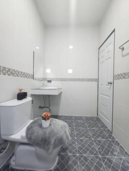 Modern bathroom with white fixtures, tiled flooring, and bright lighting