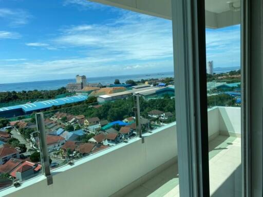 View from high-rise balcony overlooking a coastal town with clear skies