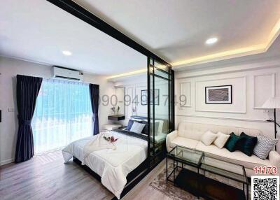 Modern bedroom with a glass partition and an adjoining living area