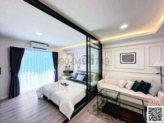Modern bedroom with a glass partition and an adjoining living area