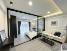 Modern bedroom with attached living area and large glass partition