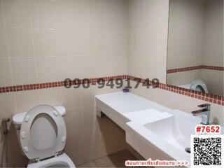 Modern bathroom with tiled walls and white fixtures