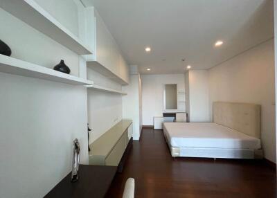 Contemporary bedroom with built-in shelving and wooden flooring