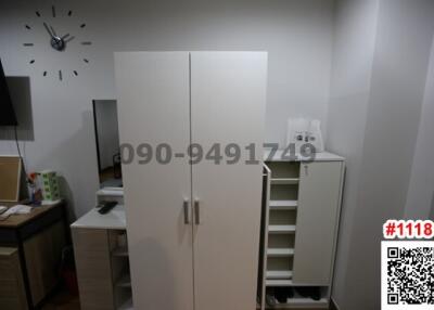 Compact bedroom with modern furniture including wardrobe and shelving unit